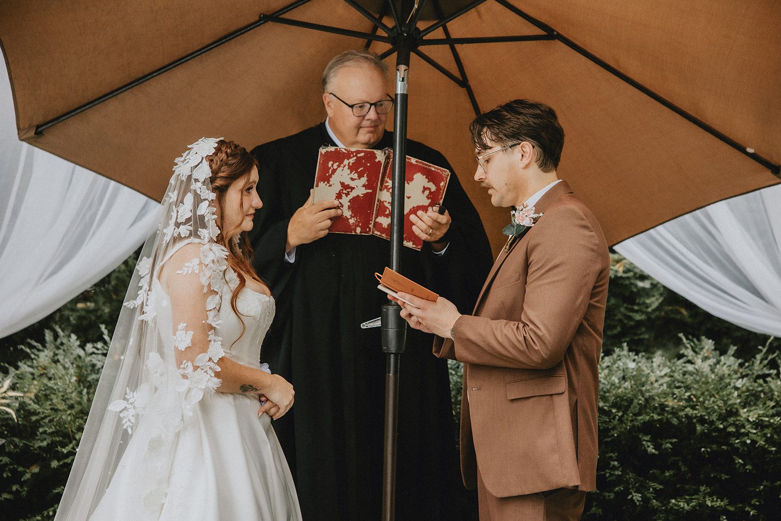 Bride and groom exchanging vows with their officiant, captured by Detroit wedding photographers from Original Weddings at The Z Hall