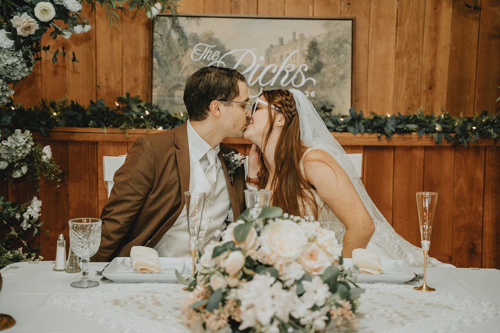 Bride and groom kissing at their sweetheart table