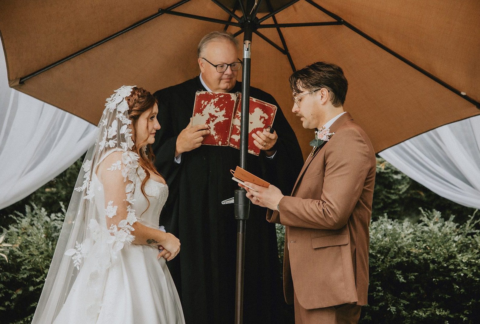 Bride and groom exchanging vows with their officiant, captured by Detroit wedding photographers from Original Weddings at The Z Hall