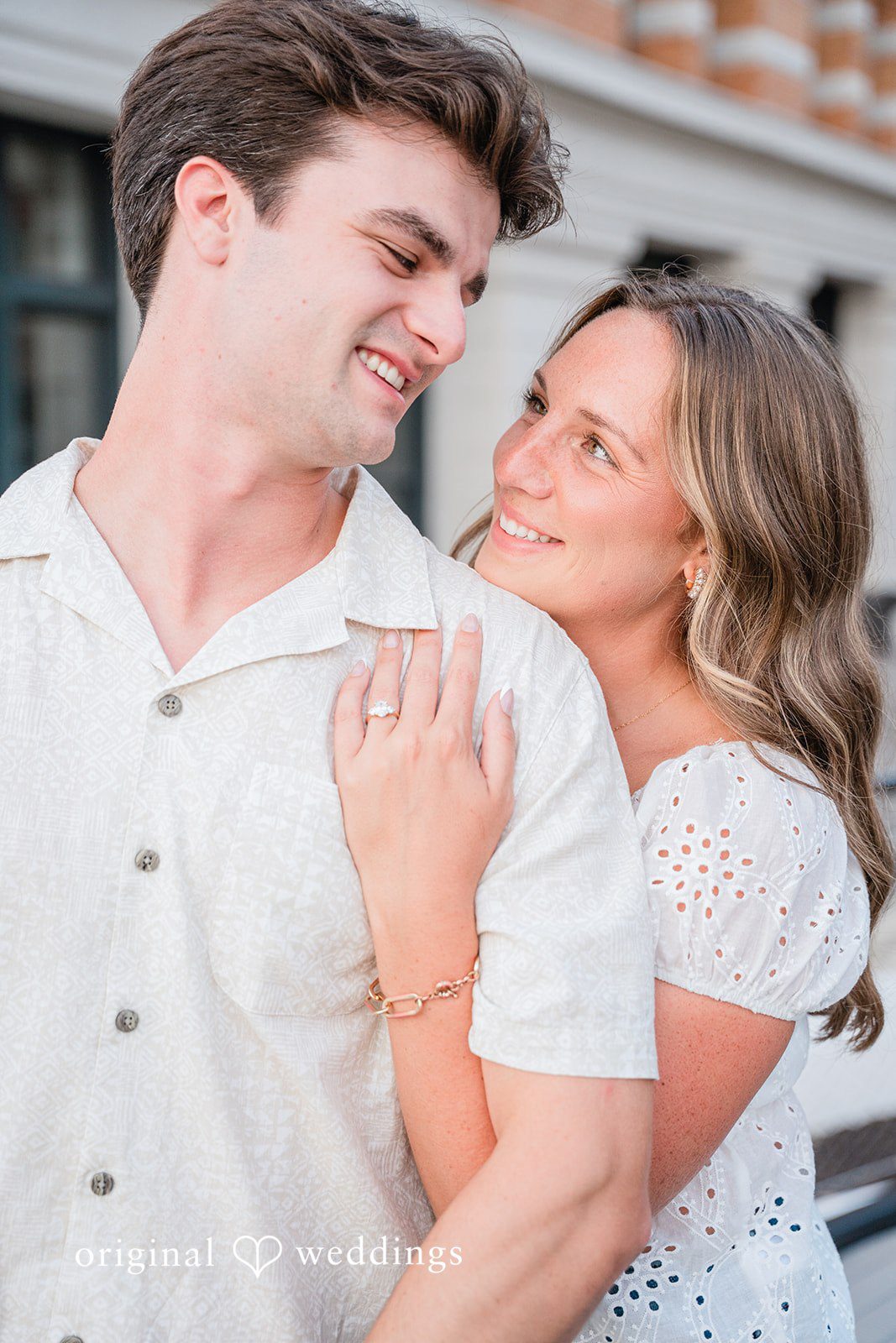 A couple smiling widely while embracing closely.