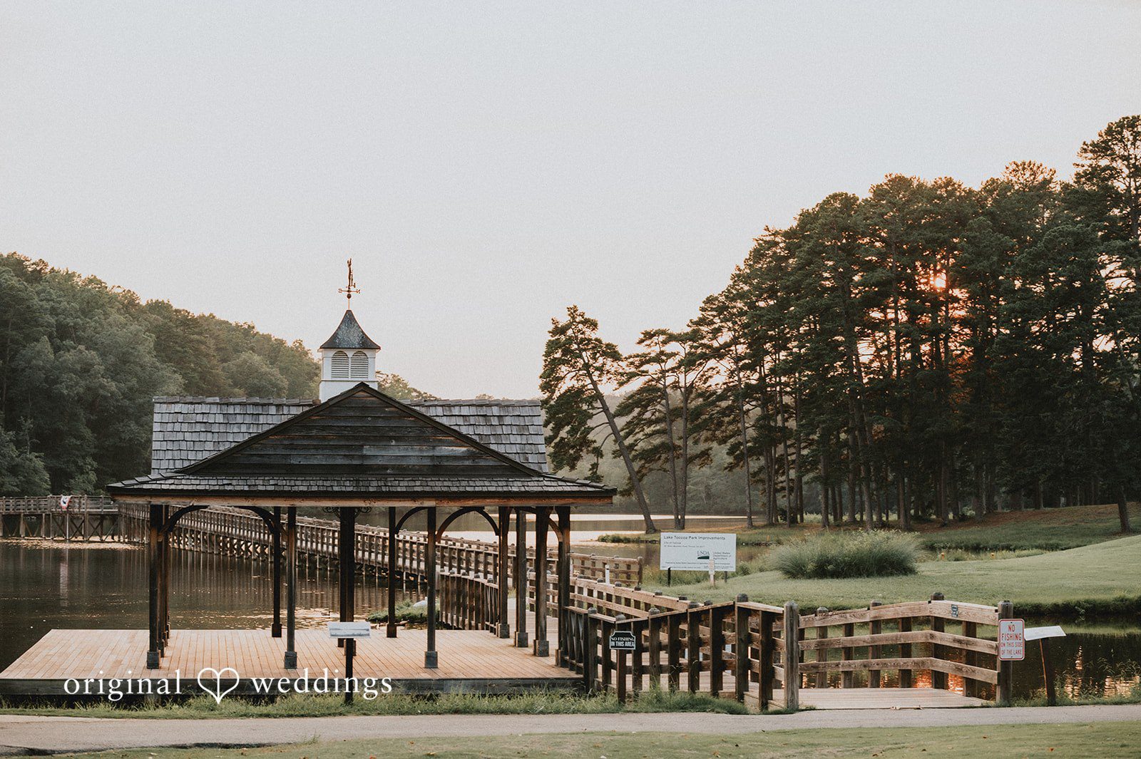 Sean + Hannah A wooden gazebo stands next to a wooden bridge over a small body of water.