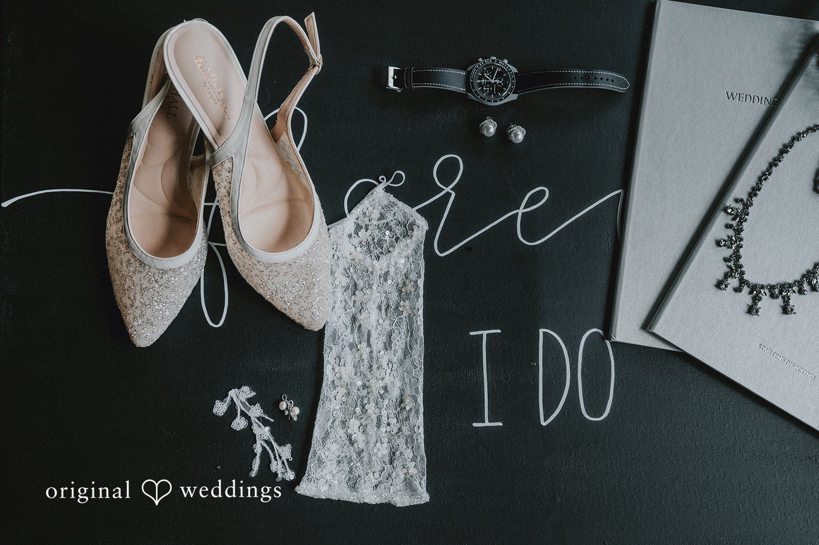 Sean + Hannah A flat lay of bridal accessories featuring light pink ballet flats and a garter belt.