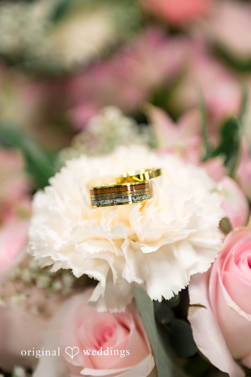 Wedding rings resting on a white flower at Tremont Cityside Ballroom