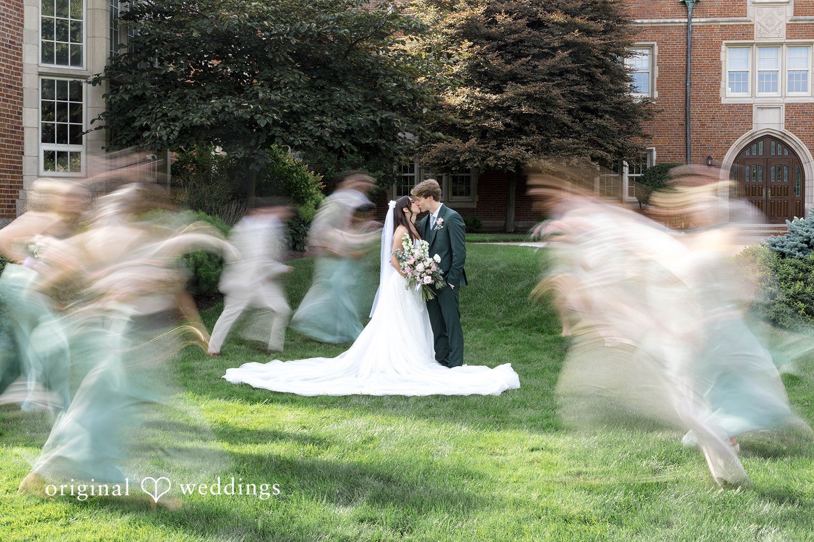 Bride and groom with the wedding party on the lawn
