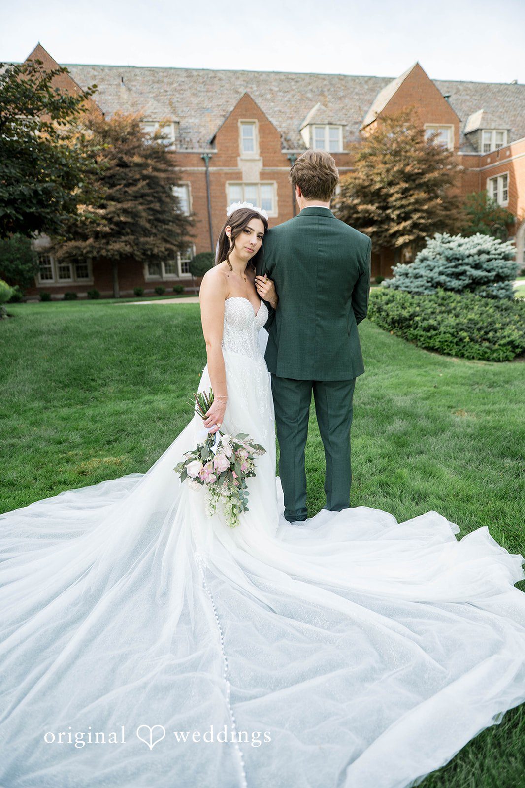 Bride's long train spread on the lawn beside the groom at Tremont Cityside Ballroom