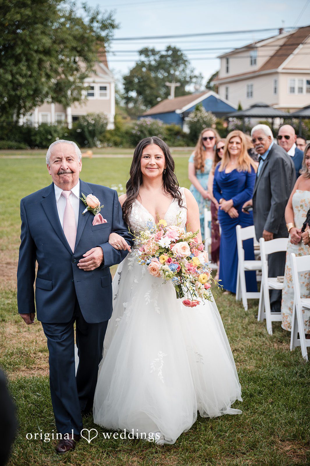 The bride's father escorts the bride down the aisle