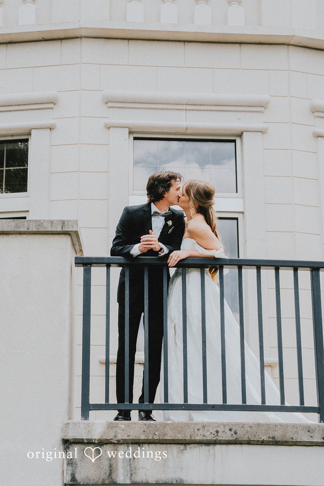 Grace + Andre Bride and groom kissing on a balcony at Veterans Terrace