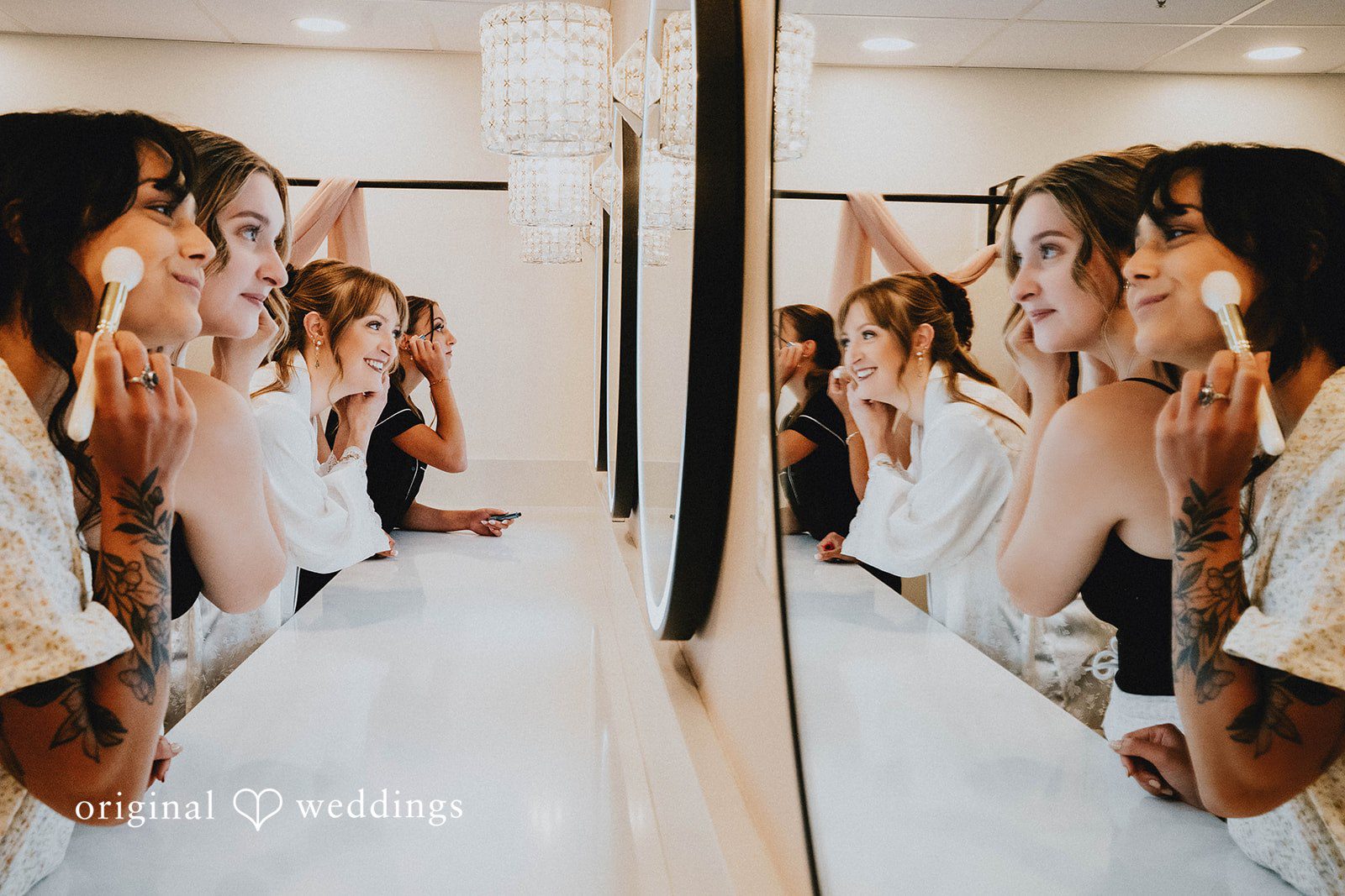 Grace + Andre Bride getting ready in front of a mirror with a friend nearby