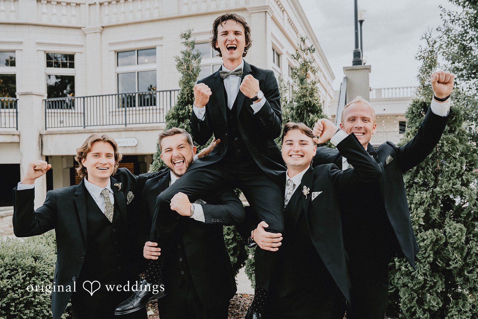 Grace + Andre Groom and groomsmen cheering together at Veterans Terrace