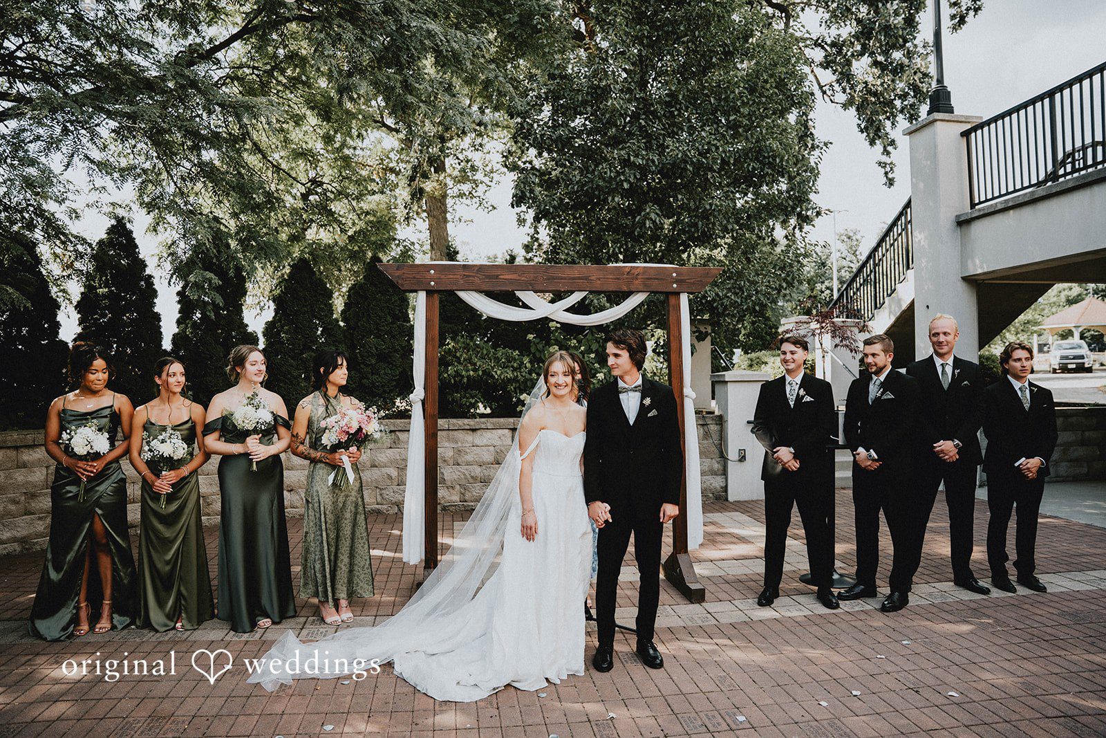 Grace + Andre Wedding party standing beside the couple during the outdoor ceremony at Veterans Terrace
