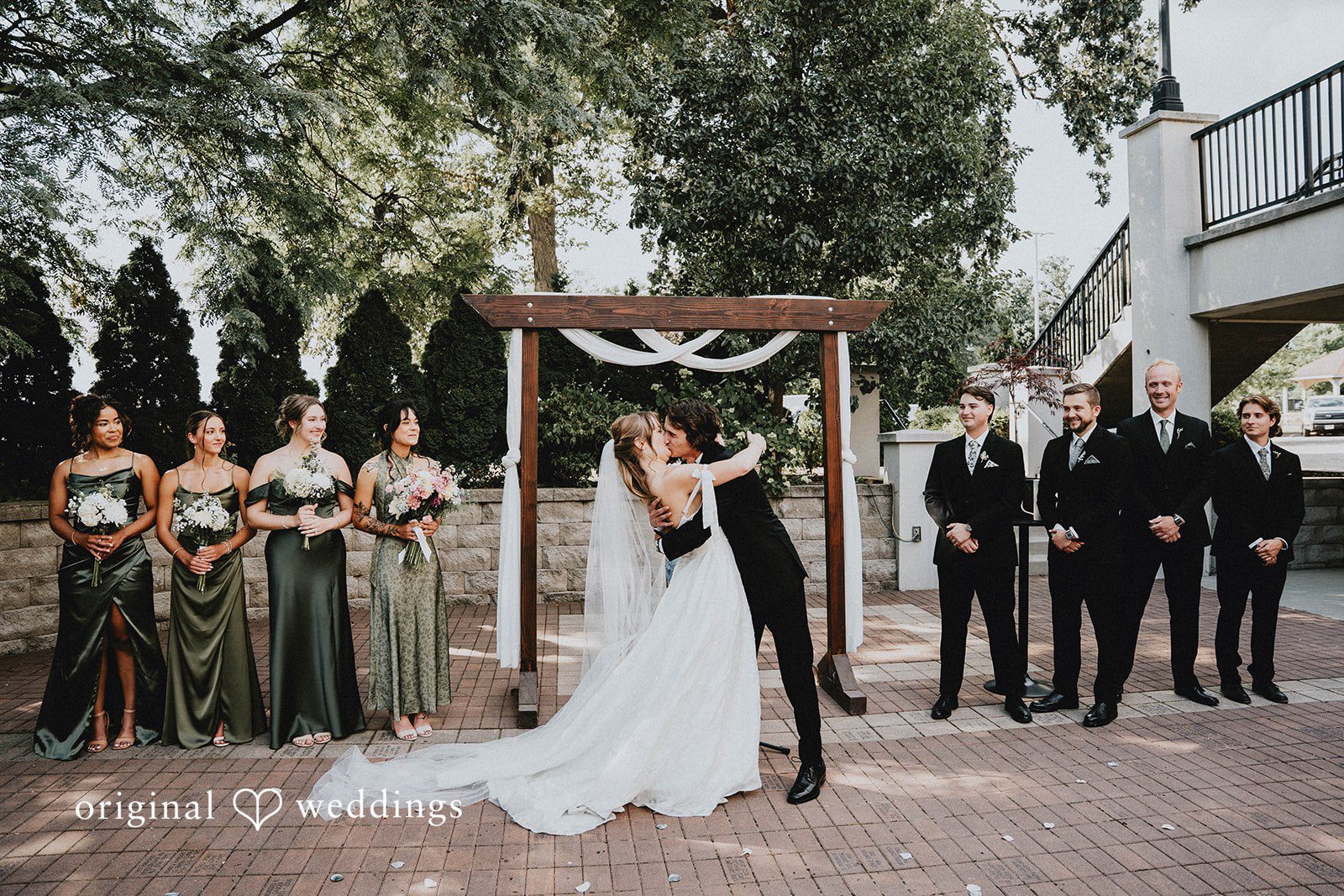 Grace + Andre Wide view of the outdoor wedding ceremony under a wooden arch at Veterans Terrace