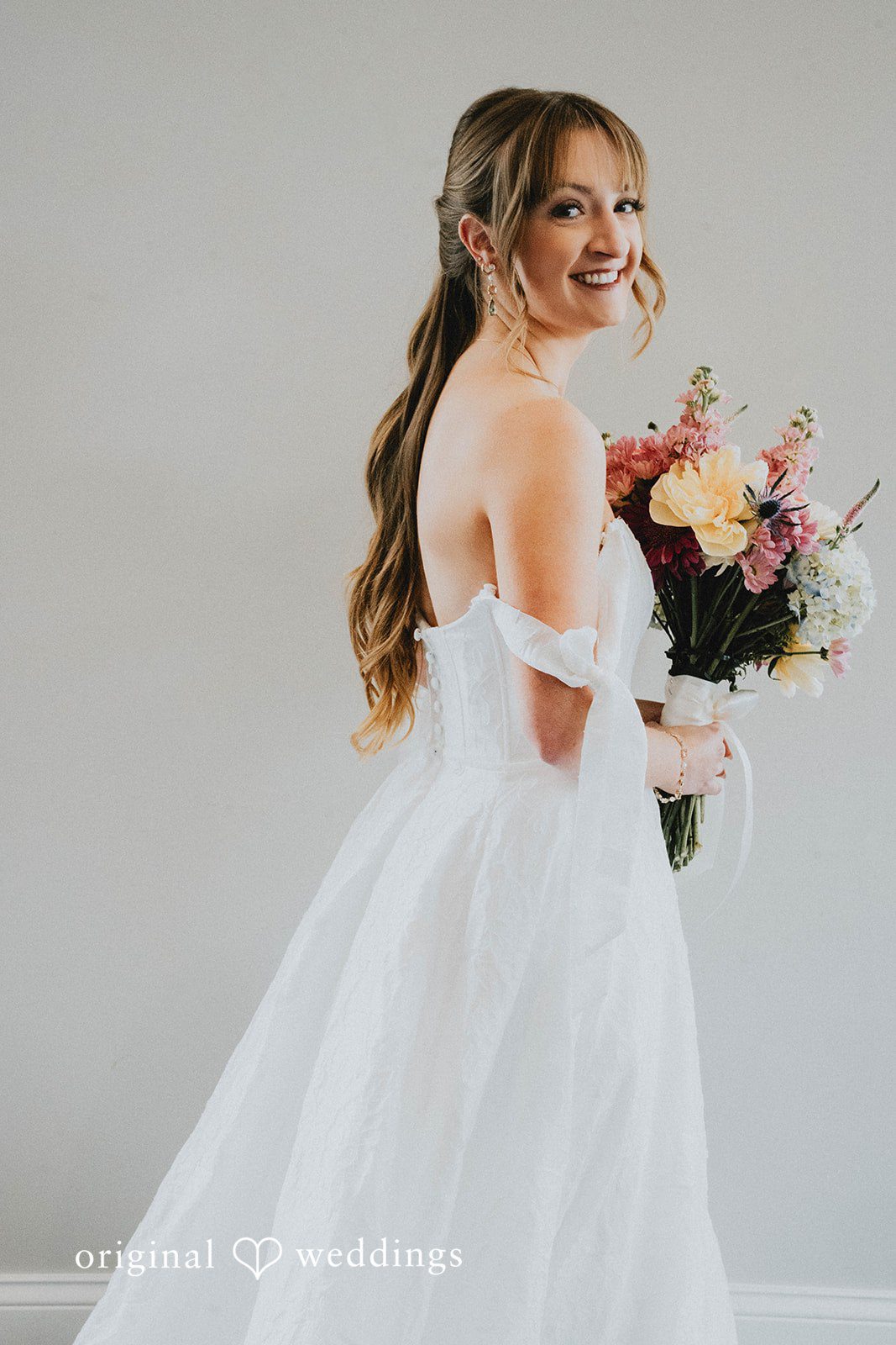 Grace + Andre Bride posing in her wedding dress with her bouquet