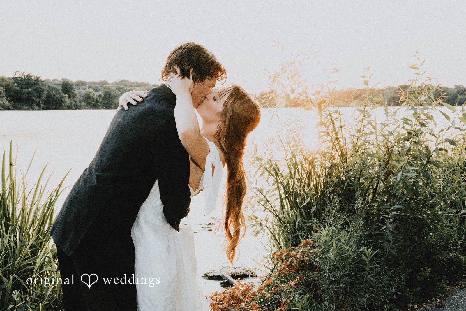 Grace + Andre Bride and groom kissing beside the lake at Veterans Terrace