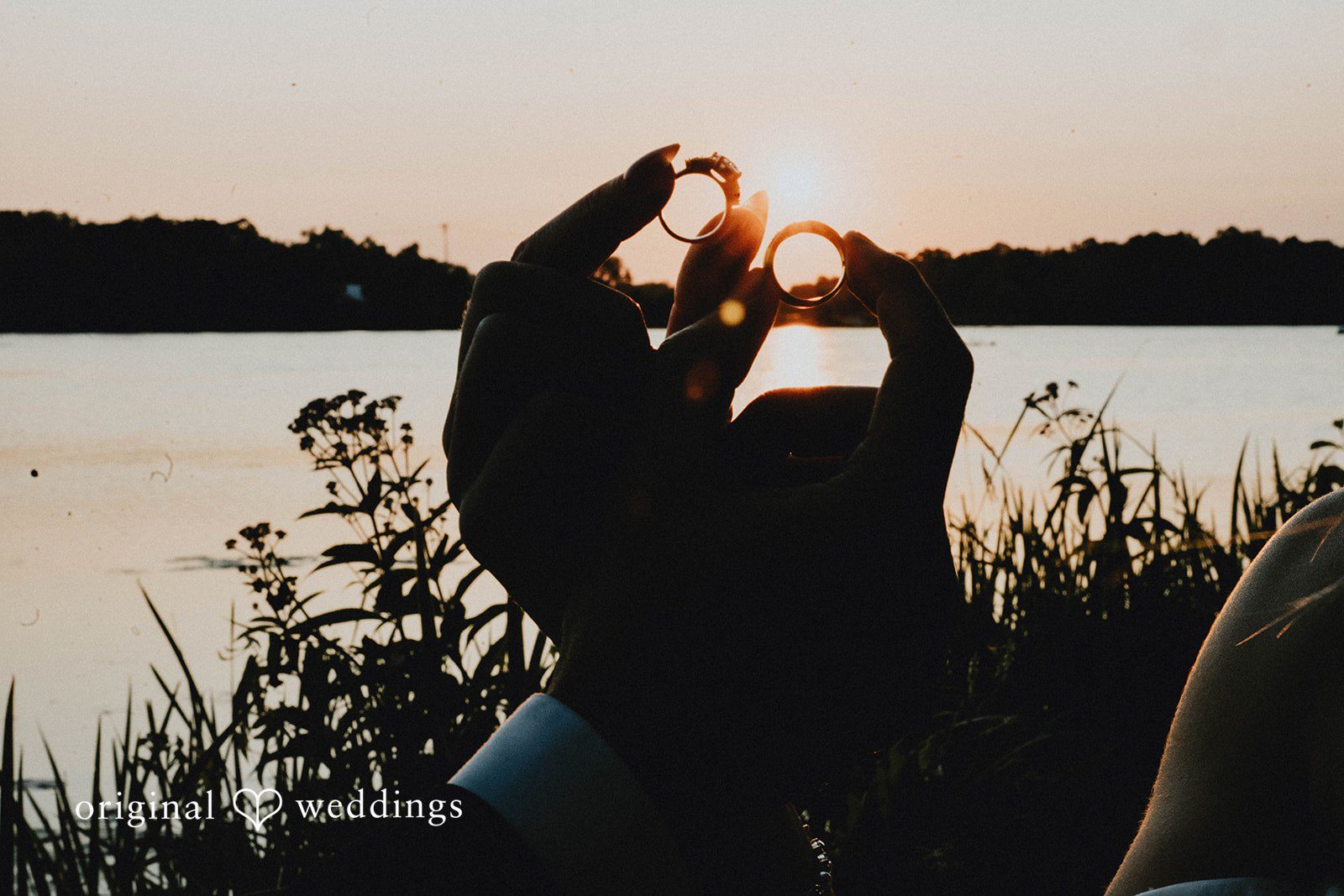 Grace + Andre Bride and groom making a heart shape at sunset over the lake