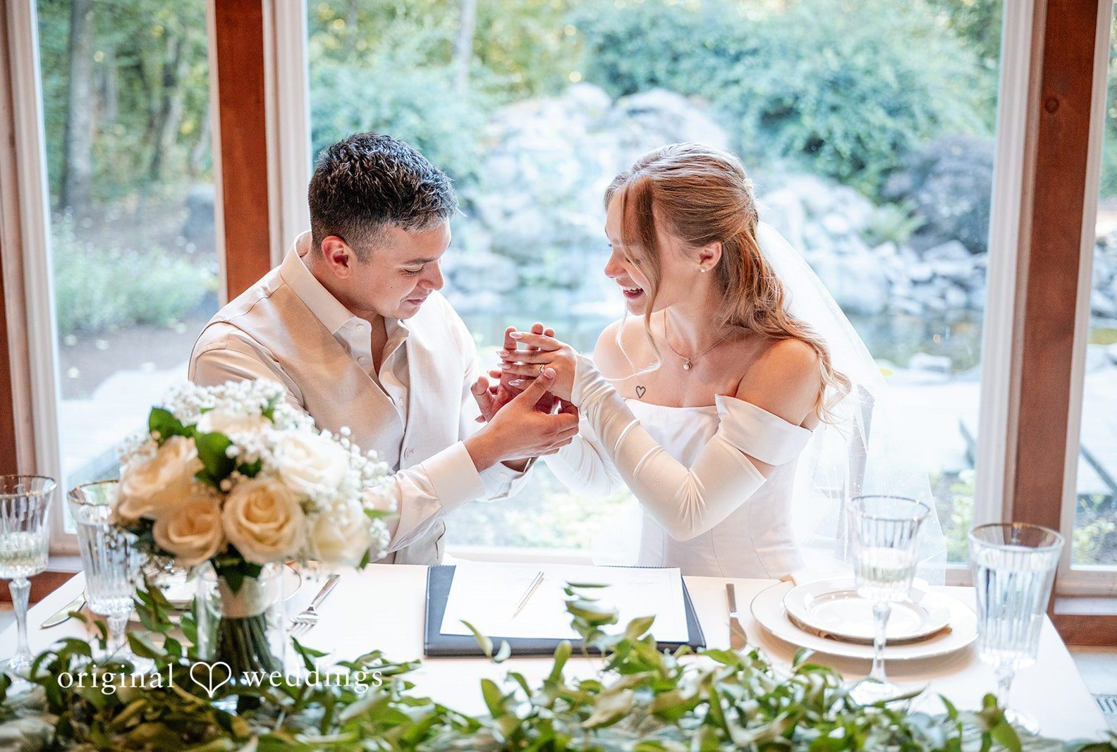 Kylie and Reymundo laughing at their reception table, captured by Portland wedding photographers from Original Weddings at Victorian Vineyard