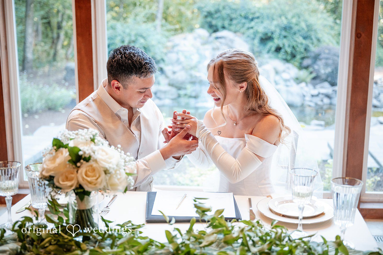 Kylie + Reymundo Kylie and Reymundo laughing at their reception table, captured by Portland wedding photographers from Original Weddings at Victorian Vineyard