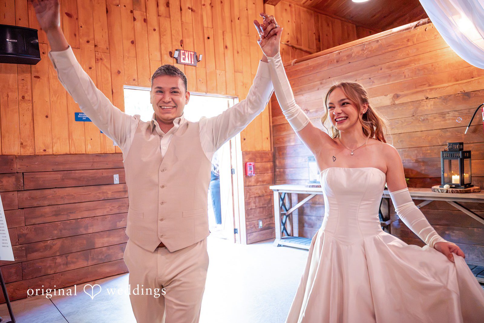 Kylie + Reymundo Kylie and Reymundo entering the reception with arms raised