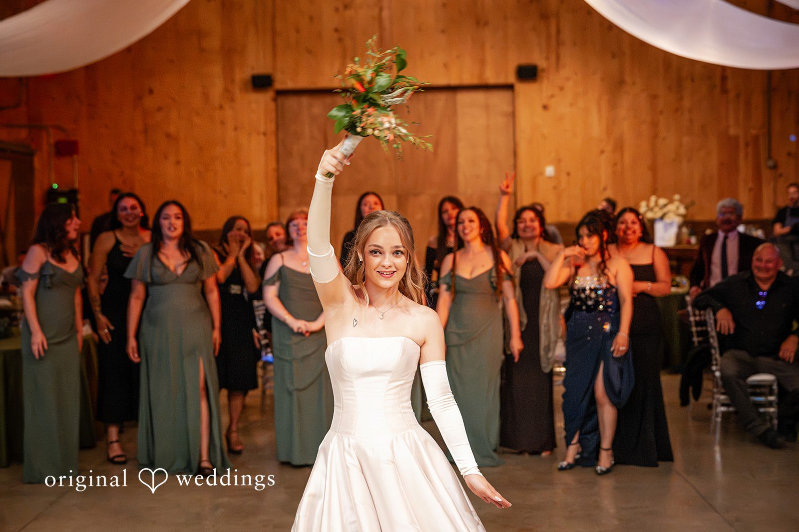 Kylie + Reymundo Bride raising her bouquet at the reception entrance
