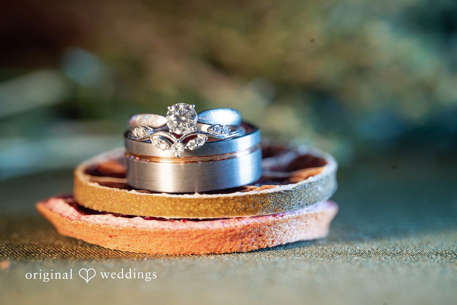 Kylie + Reymundo Wedding rings resting on a wooden slice