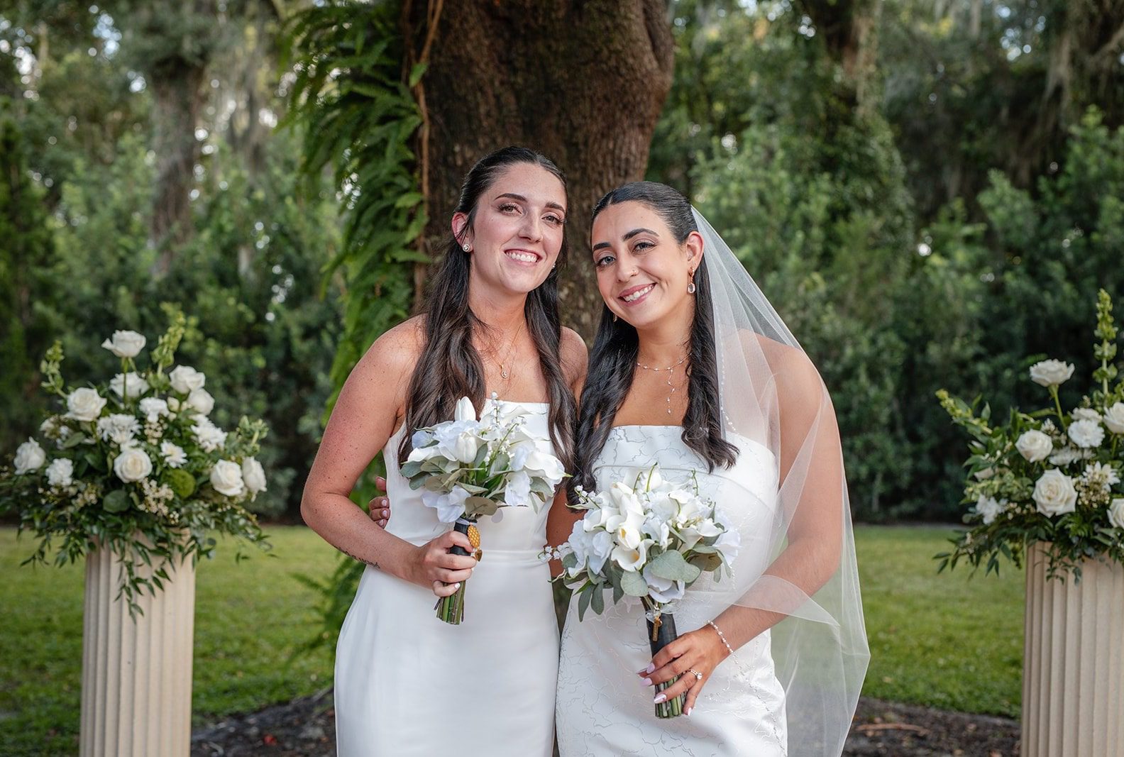 Brides smiling together with their bouquets, captured by Orlando wedding photographers from Original Weddings at Villa Festa