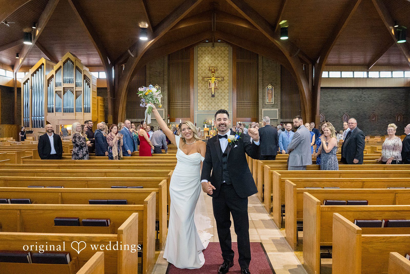 Wedding guests cheering in the church pews