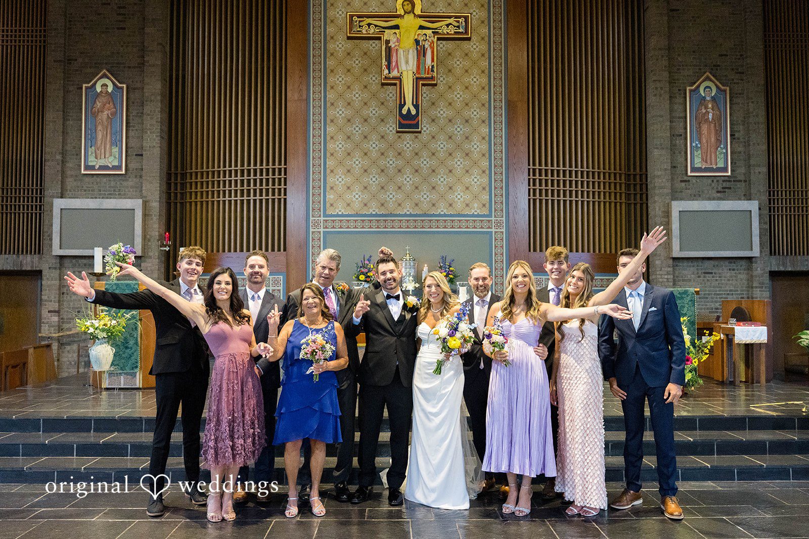 Wedding party cheering with the couple at the altar