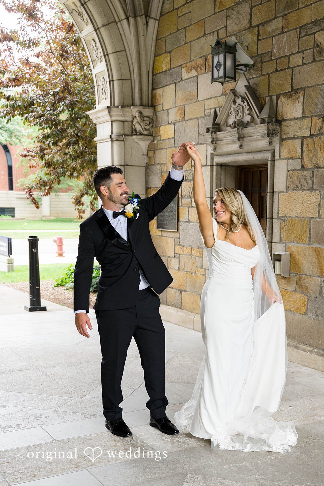 Groom twirling the bride in the courtyard on their Vinology wedding day