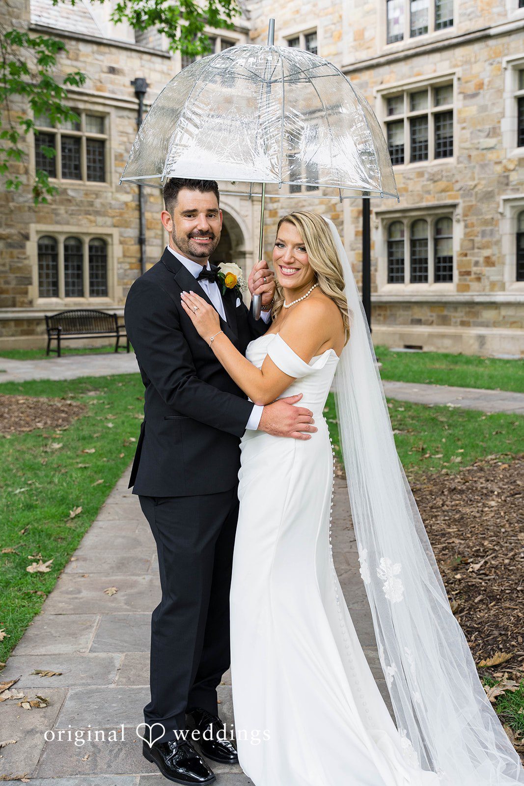 Couple embracing beside an ivy covered wall