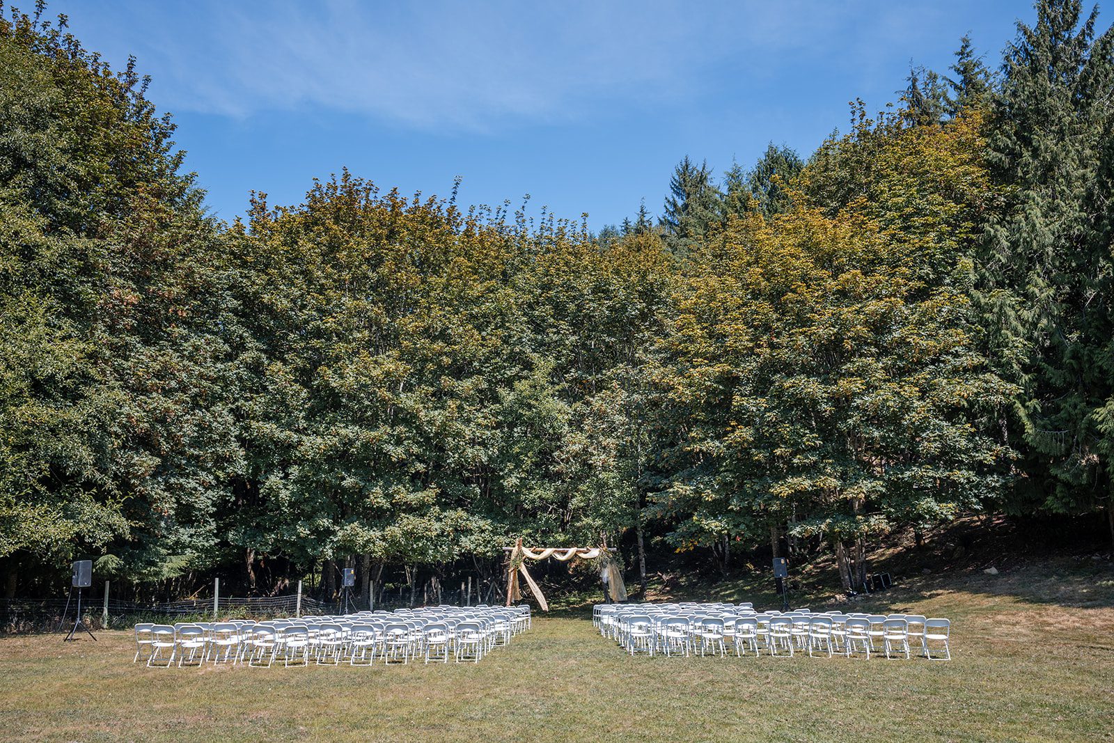 washington-backyard-timeless-seattle-beth-gunner-p001-20 Forest ceremony setup with rows of chairs at a Washington backyard wedding