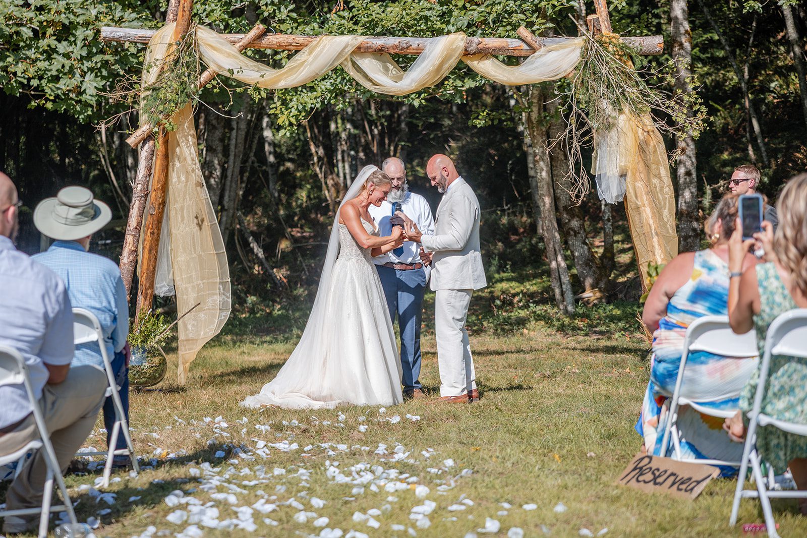 washington-backyard-timeless-seattle-beth-gunner-p010-25 Couple exchanging vows under the arch at a Washington backyard wedding