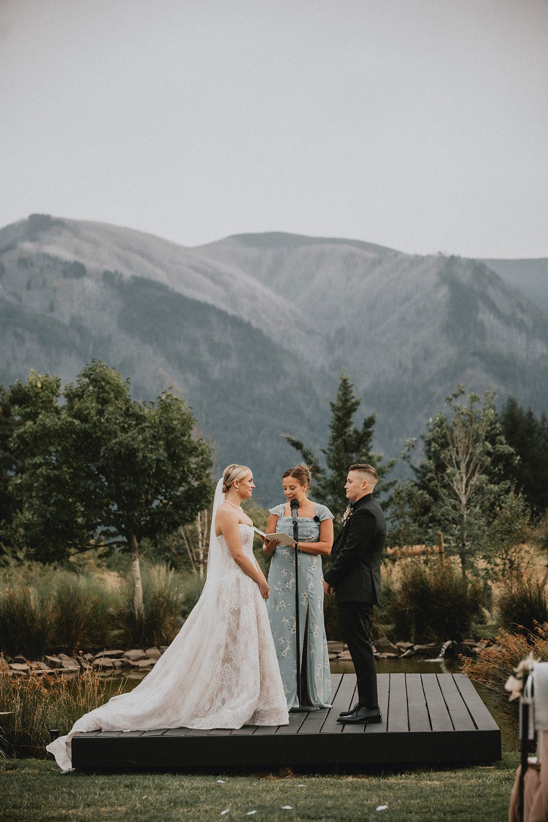 wind-mountain-ranch-rustic-portland-cj-rachel-p012-10 Couple at the ceremony stage with mountains behind them at Wind Mountain Ranch