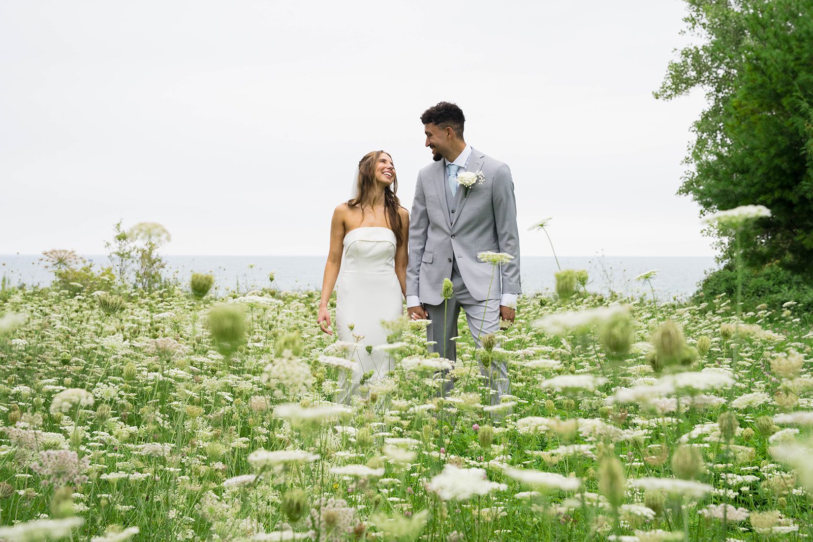 Bride and groom walking through the field