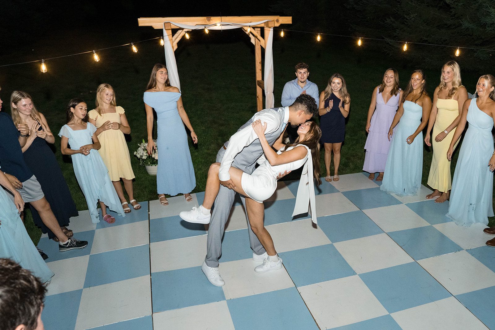 Guests dancing with the newlyweds in the backyard