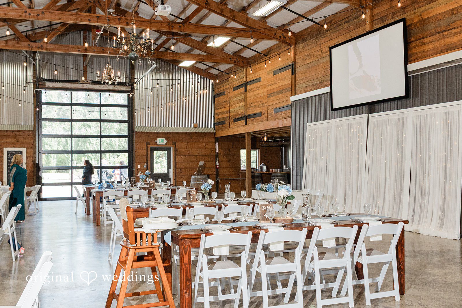 Rachel + Matt Barn reception space set with tables at Wisteria Gardens