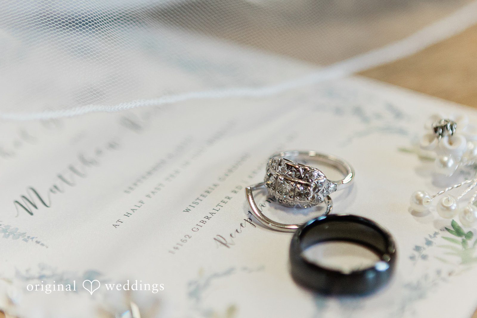 Rachel + Matt Wedding rings resting on the invitation