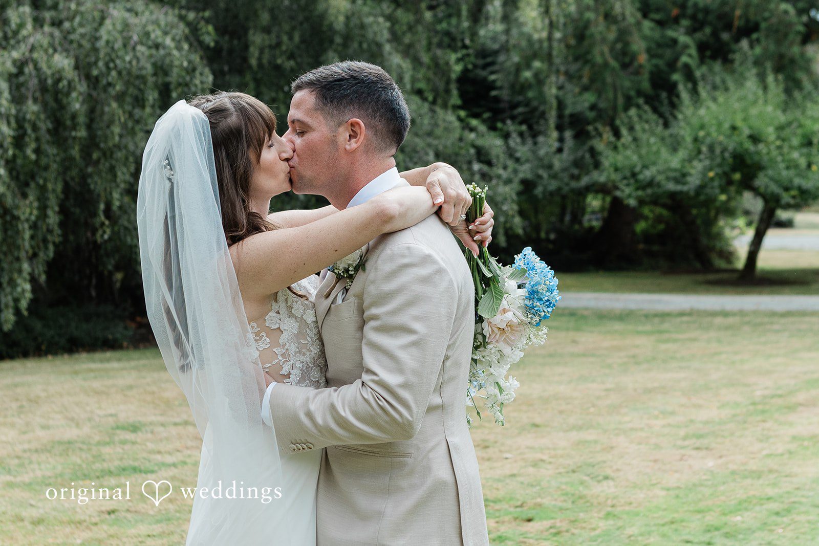 Rachel + Matt Couple sharing a kiss on the lawn at Wisteria Gardens