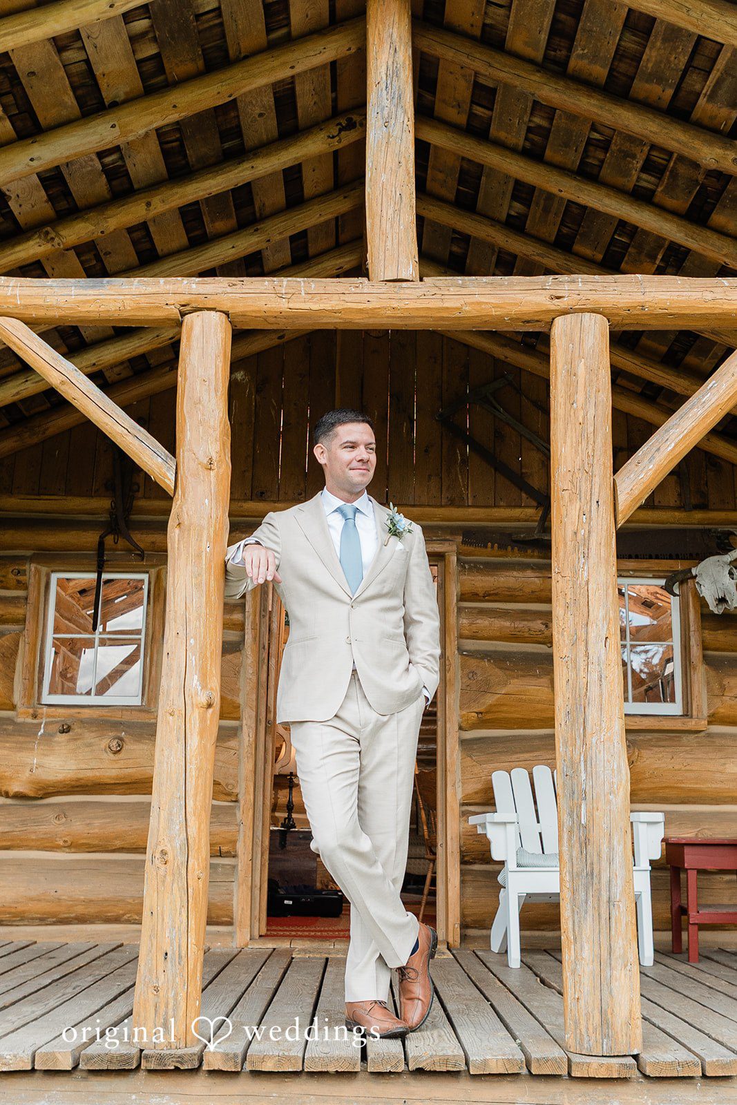Rachel + Matt Groom standing in the wooden pavilion at Wisteria Gardens