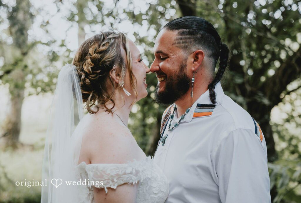 Alex and Simon smiling together among the trees, captured by Seattle wedding photographers from Original Weddings at Woodland Meadow Farms