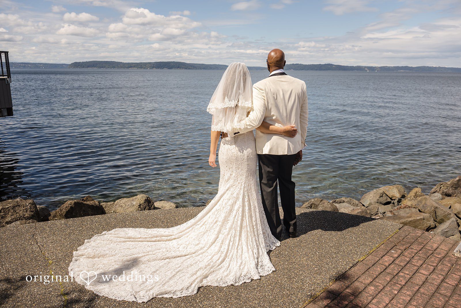 Jennifer + Tony A bride and groom posing for photos on a walkway next to the waterfront.