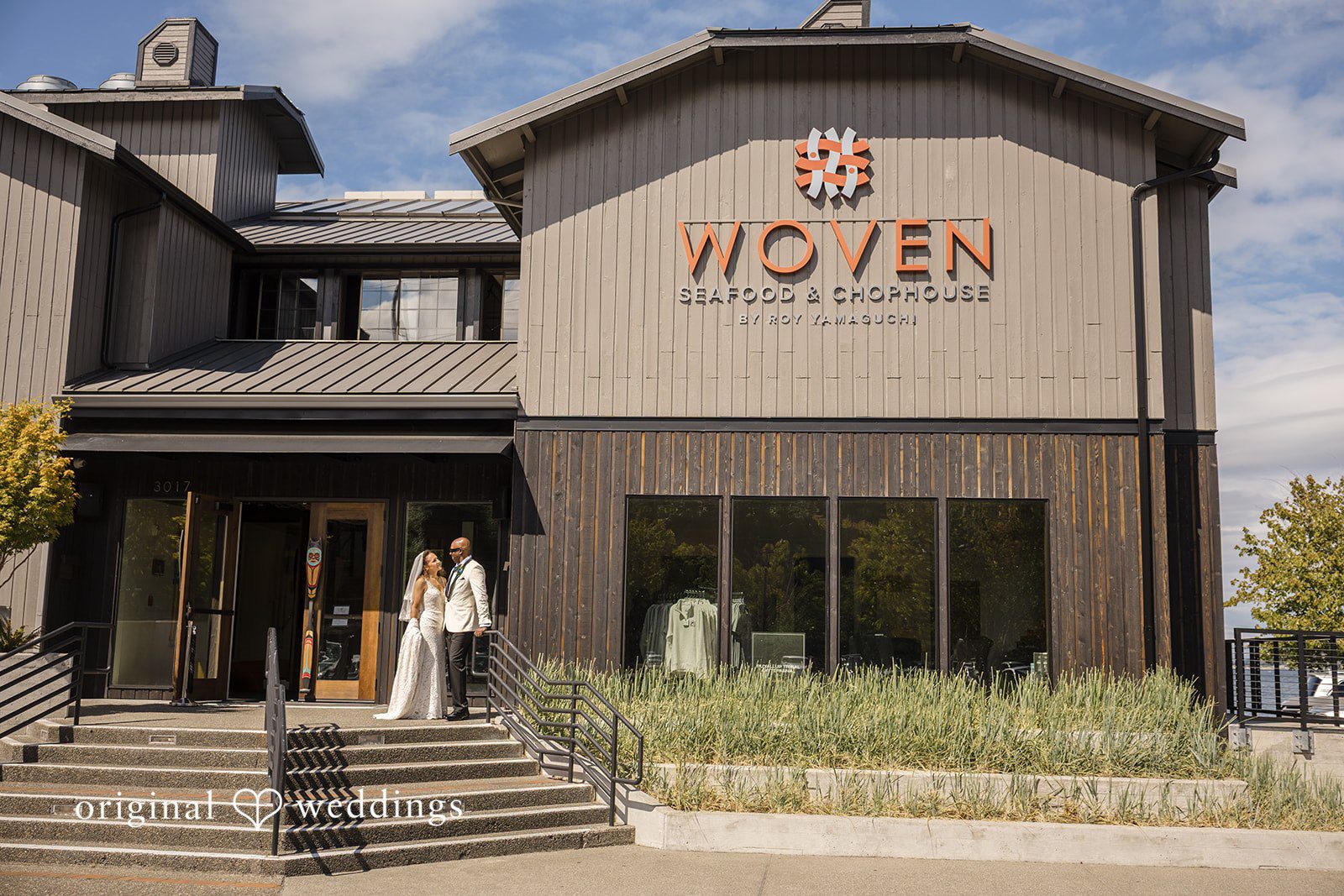 Jennifer + Tony A wide shot of a modern dark wooden building named "The Oven" near the water.