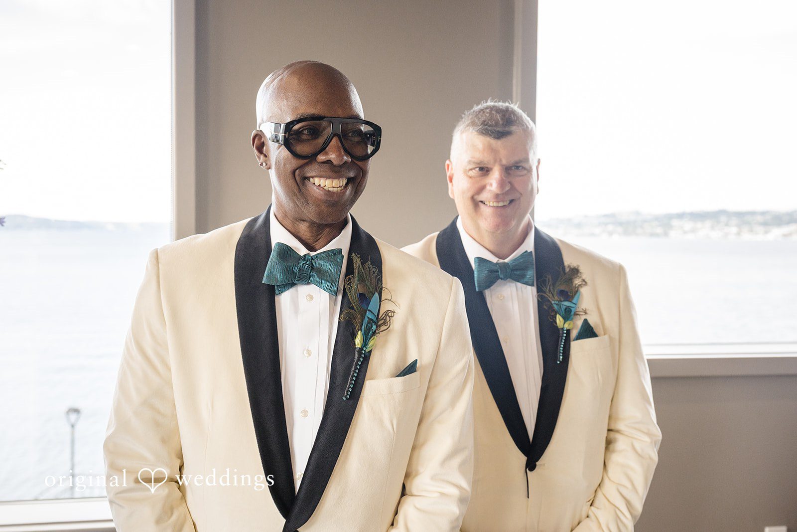 Jennifer + Tony A groom in a white tuxedo standing beside his best man in a matching suit.