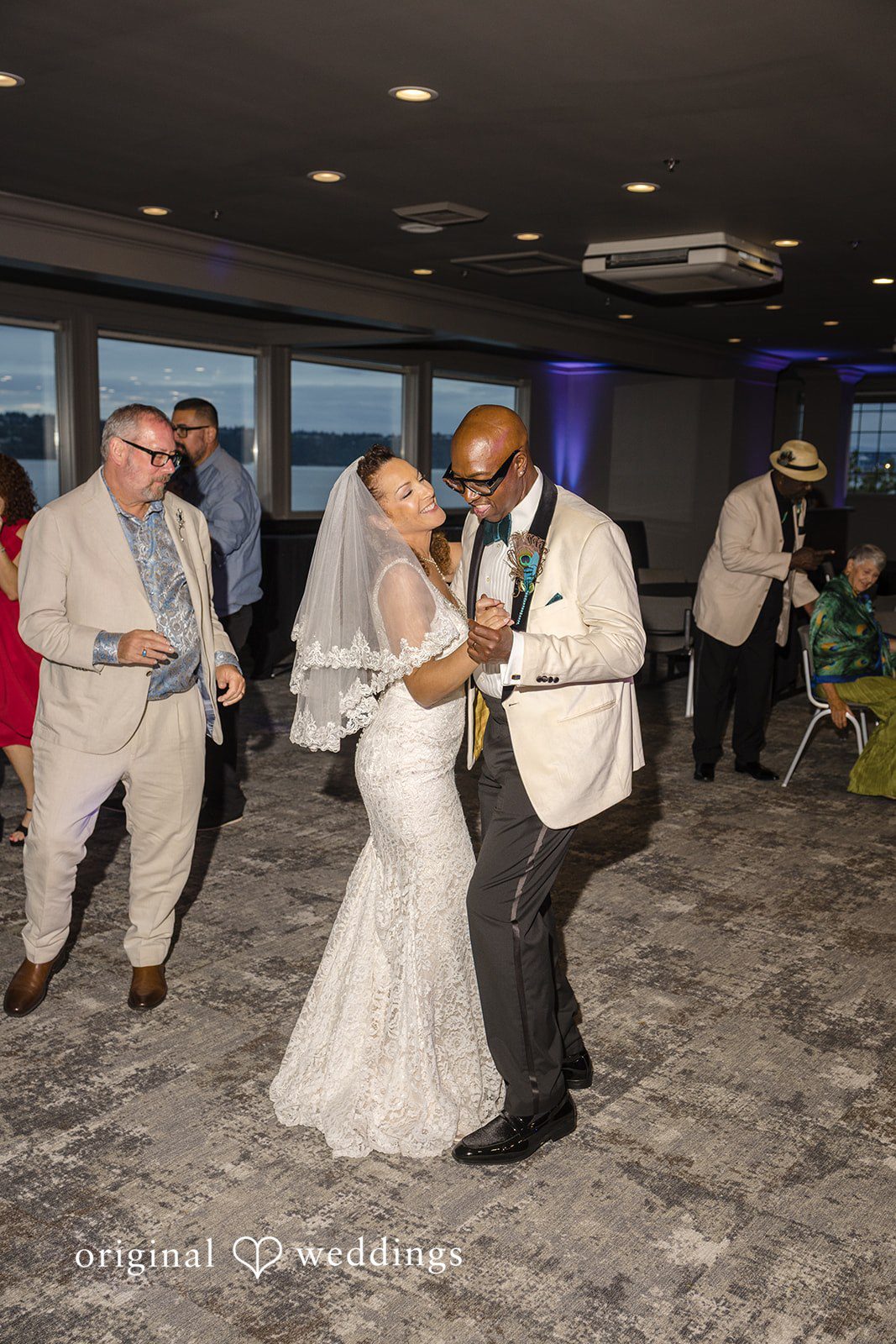 Jennifer + Tony A bride and groom dancing together in the center of a crowded reception hall.